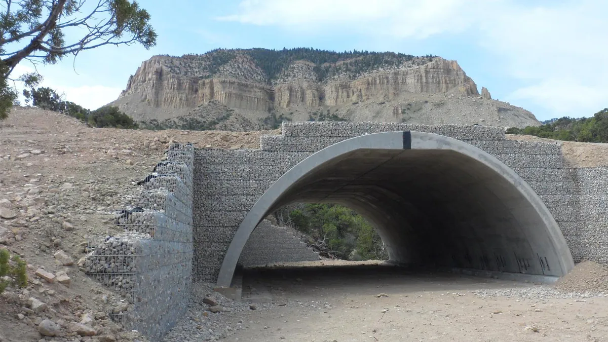 Gabion retaining walls flanking a precast concrete arch culvert